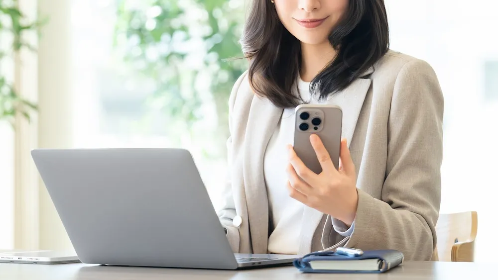スマートフォンとノートPCを使う女性